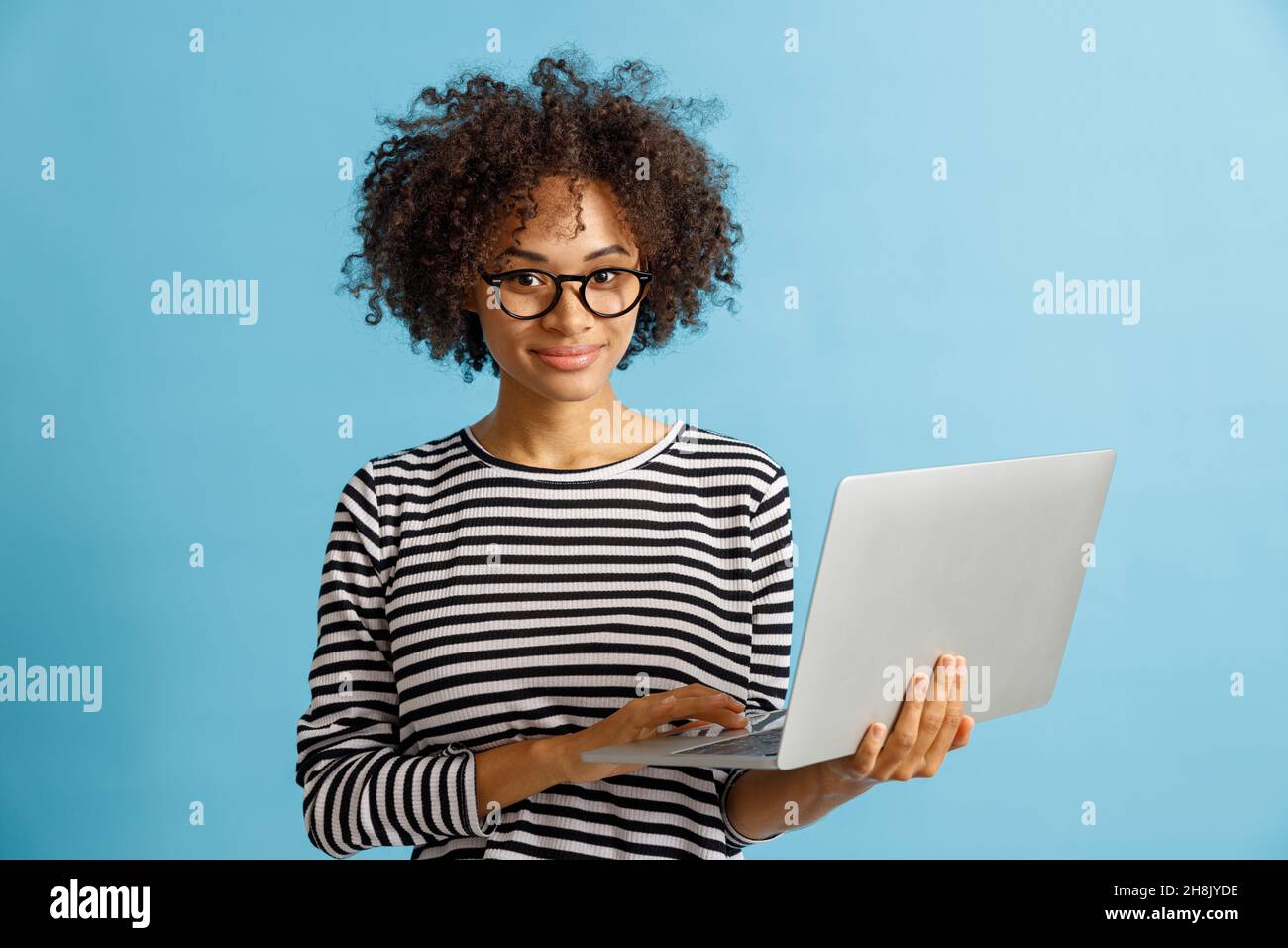 Joyful young woman using notebook in studio Stock Photo