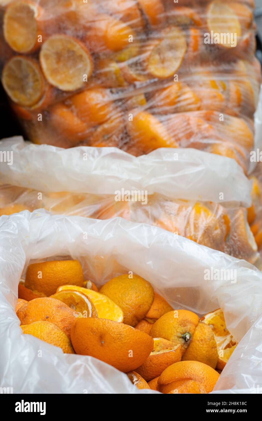 Lots of leftover orange peels in plastic bags. Old and used oranges thrown away after have been