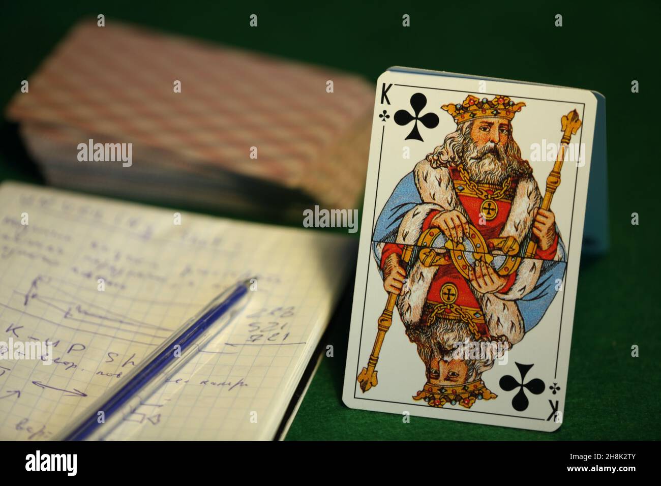 king of cross, deck of cards, paper with notes on a green cloth, card game for money, still life Stock Photo