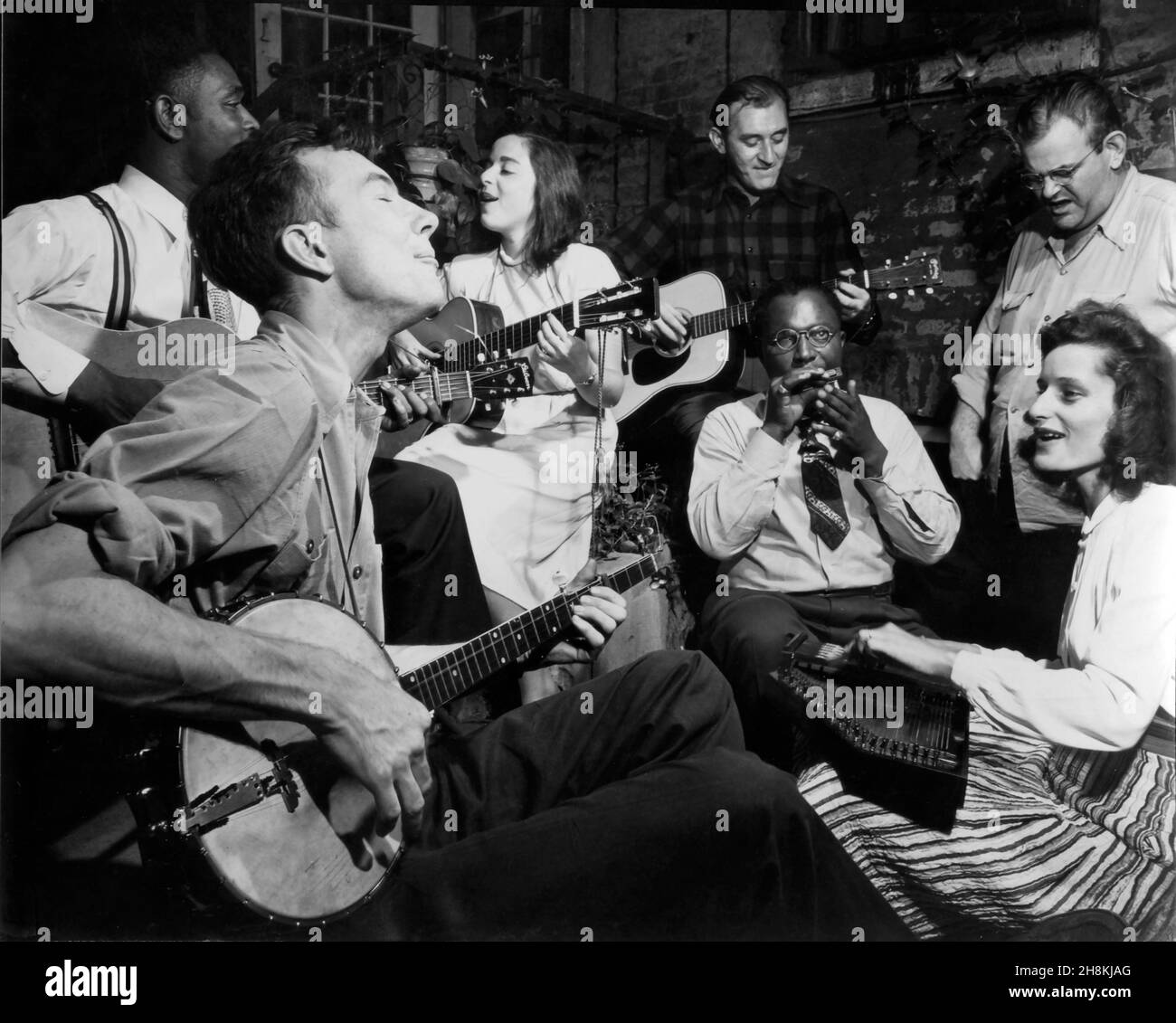 Pete Seeger playing banjo along with other musicians circa 1950s. Stock Photo