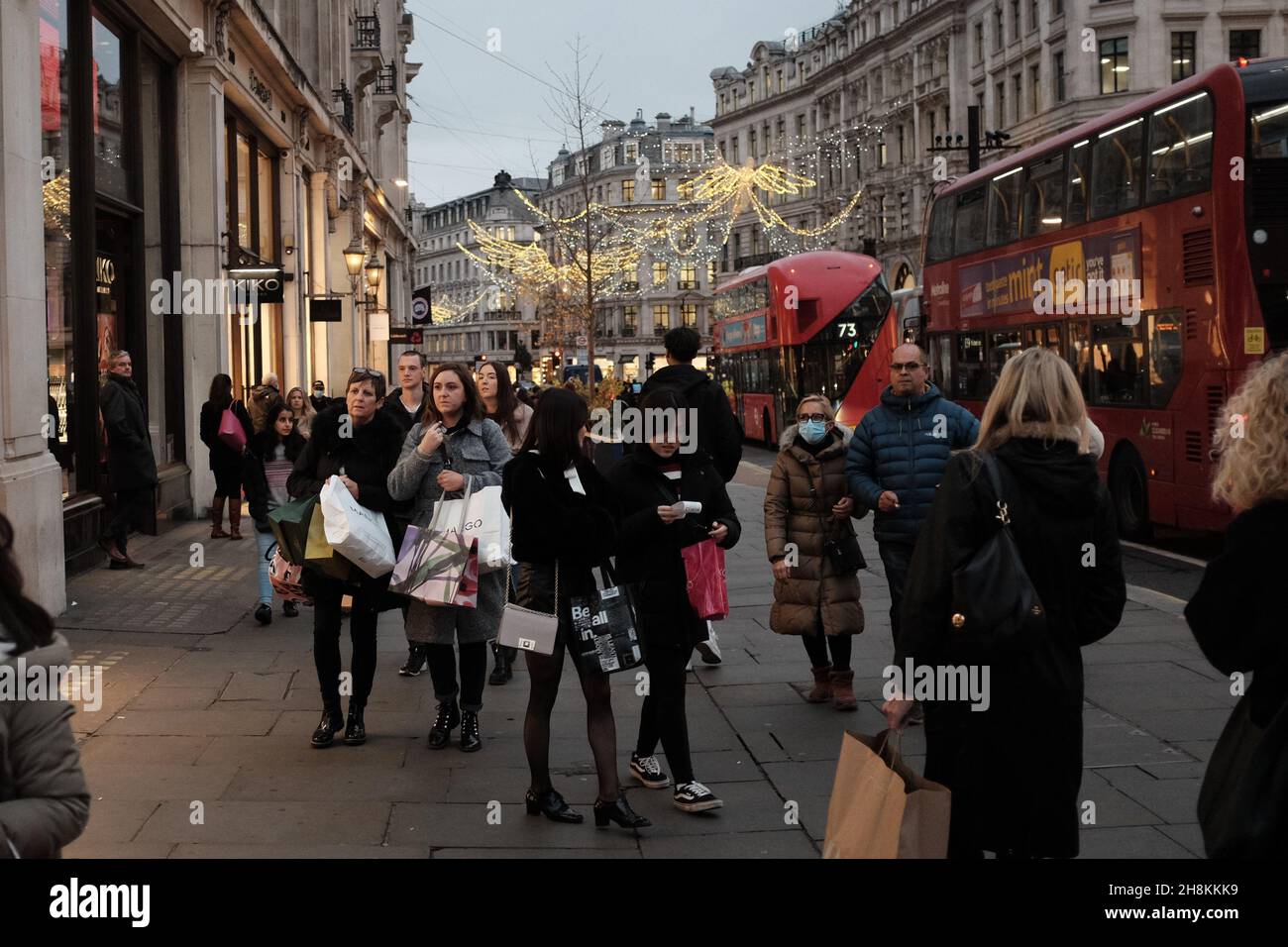 London, Britain. 24th Nov, 2021. People with shopping bags walk on Regent Street in London, Britain, Nov. 24, 2021. Consumers across Britain are expected to face higher prices and fewer choices for goods this Christmas season due to supply chain delays and soaring inflation. TO GO WITH "Economic Watch: Supply chain delays, inflation surge across UK may lead to "tough" Christmas" Credit: Tim Ireland/Xinhua/Alamy Live News Stock Photo