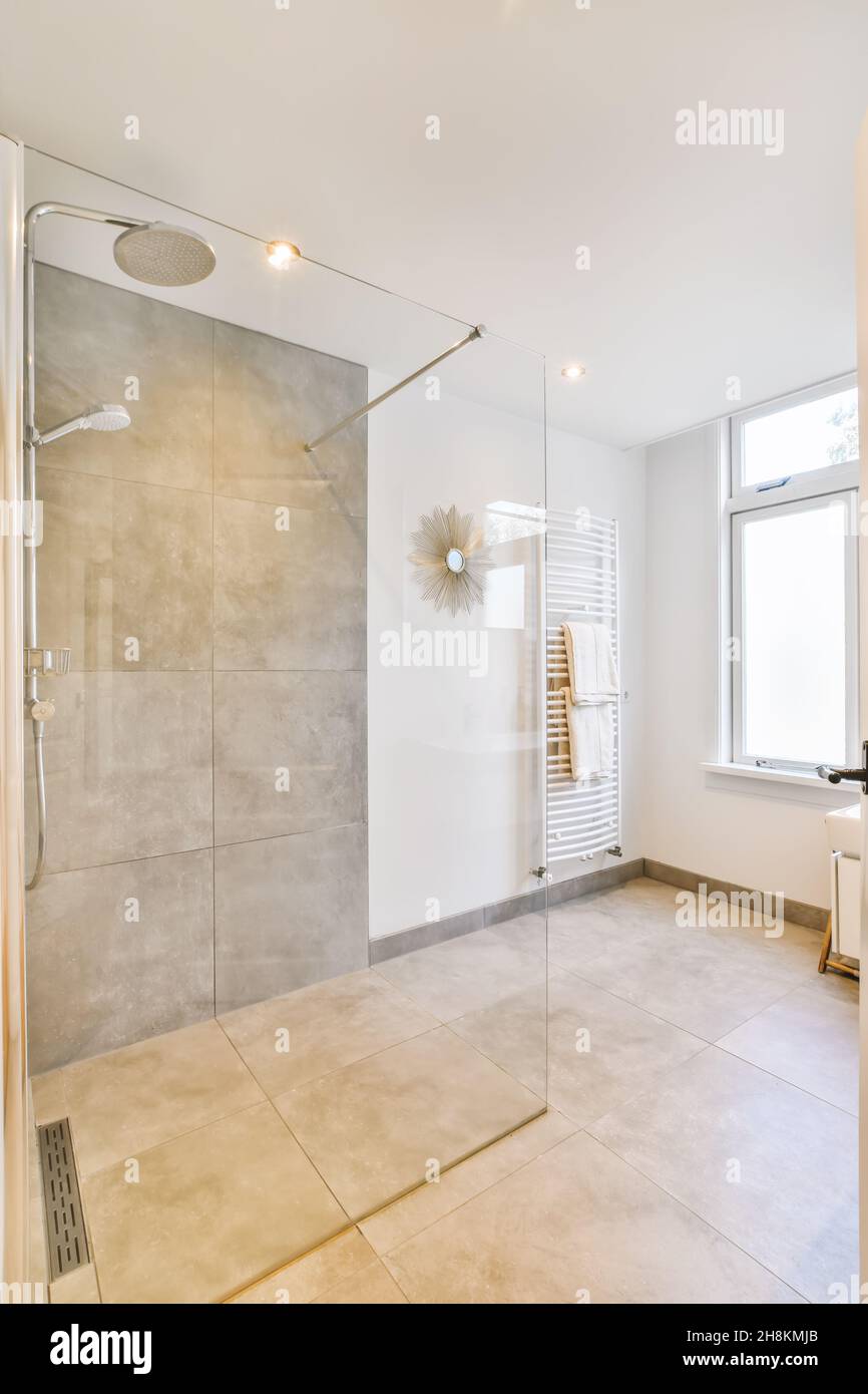 Designer bathroom with beige tiled floor and gray white walls Stock ...