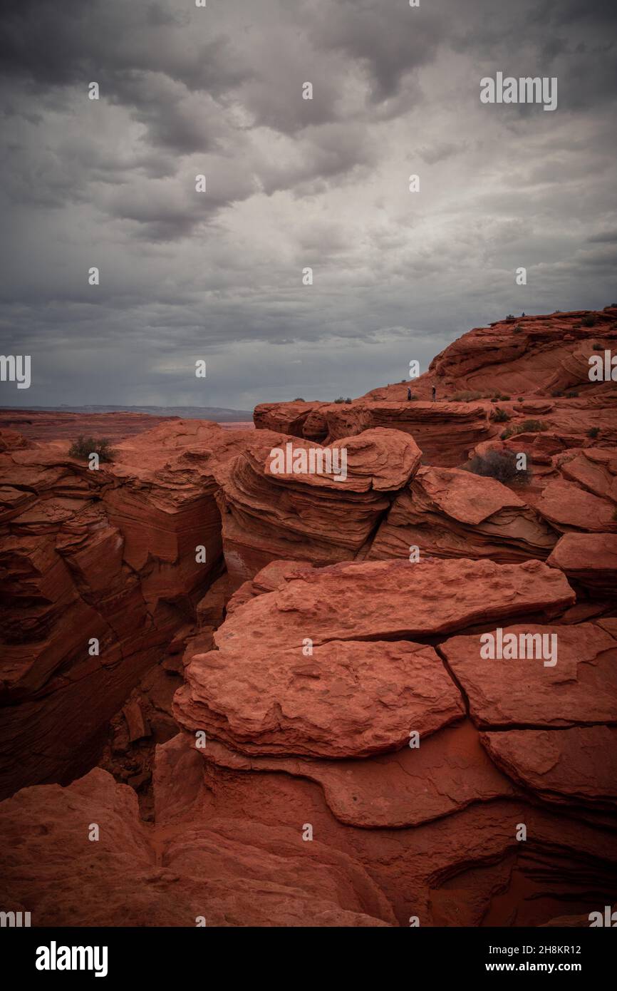 View of Wavy Stones Made with Red Rock,  storm clouds in the sky, Horseshoe Bend, Page, Arizona, United States Stock Photo