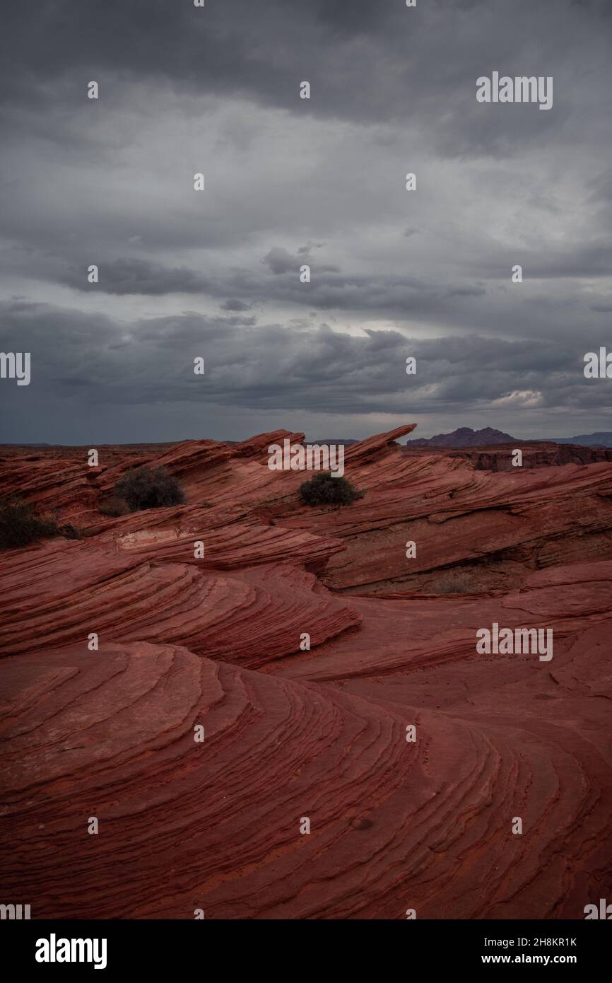 View of Wavy Stones Made with Red Rock,  storm clouds in the sky, Horseshoe Bend, Page, Arizona, United States Stock Photo