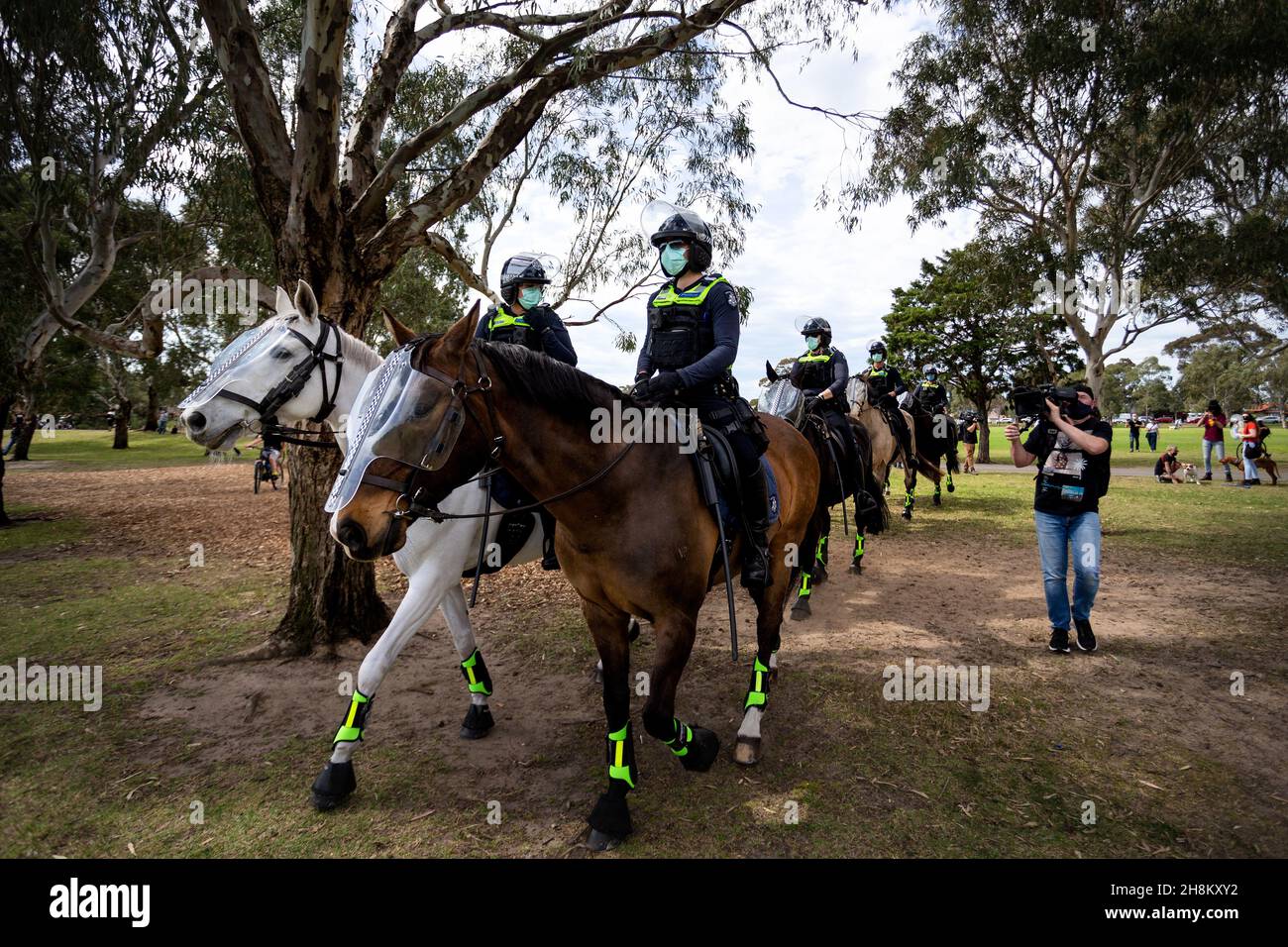 Mounted Police walk through the Elsternwick park as they push protesters back during the Freedom protest. Freedom protests are being held in Melbourne every Saturday and Sunday in response to the governments COVID-19 restrictions and continuing removal of liberties despite new cases being on the decline. Victoria recorded a further 21 new cases overnight along with 7 deaths. Stock Photo