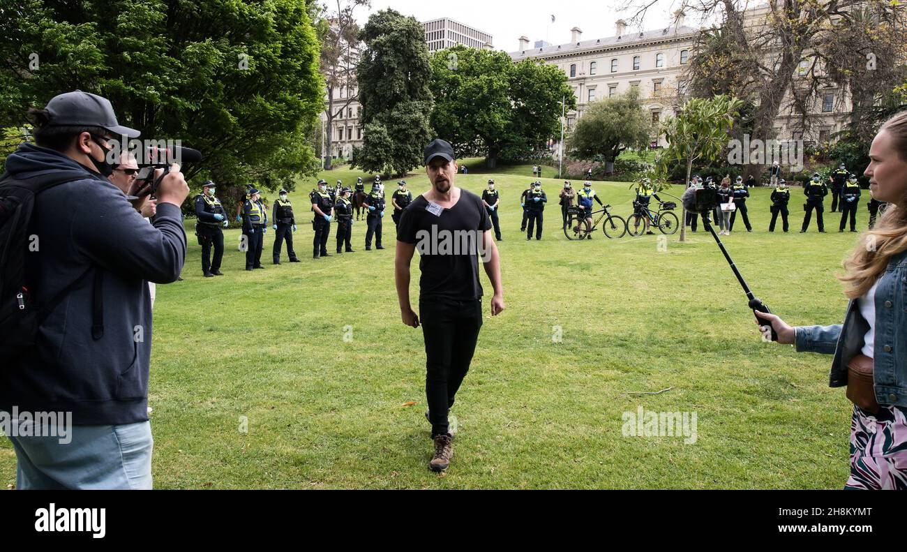 A protest leader 'Morgan' speaks to cameras and protesters as the group is encircled by police in Treasury Gardens. An anti-Daniel Andrews State Premier protest in Treasury Gardens attracted a strong police response, left protesters out numbered by mounted, public order and general duties police officers on Saturday in Melbourne CBD. (Photo by Michael Currie/Speed Media) Stock Photo