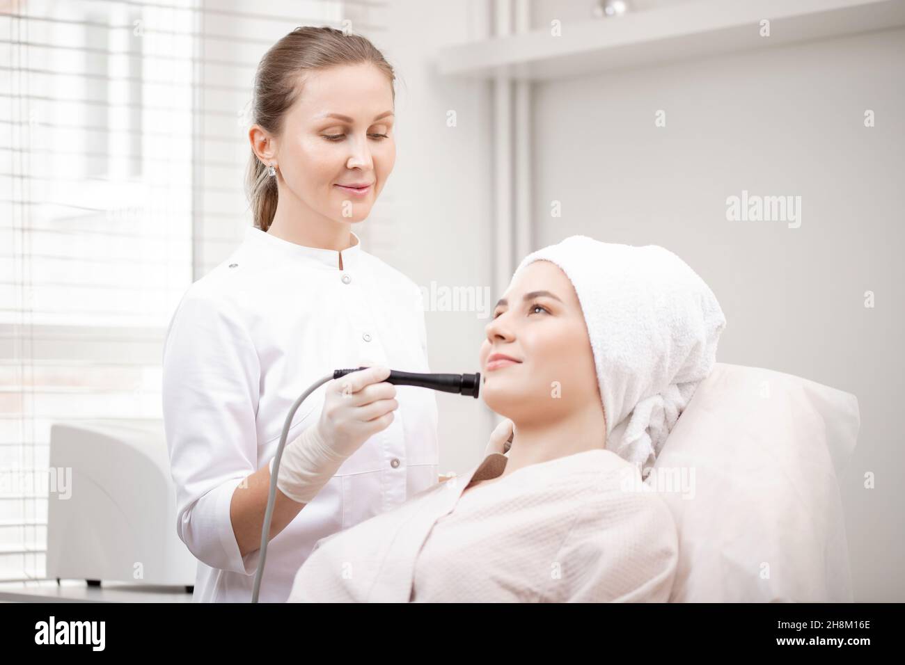 Young woman having micro current galvanic facial treatment with