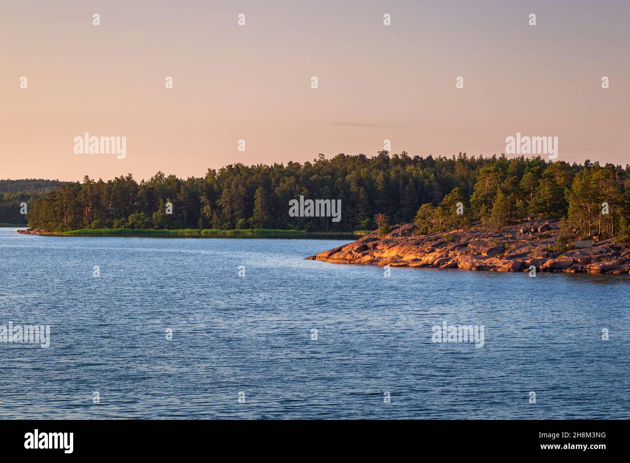 View of rocky and rugged coastline and sea in Åland Islands, Finland, at sunset in the summer. Stock Photo