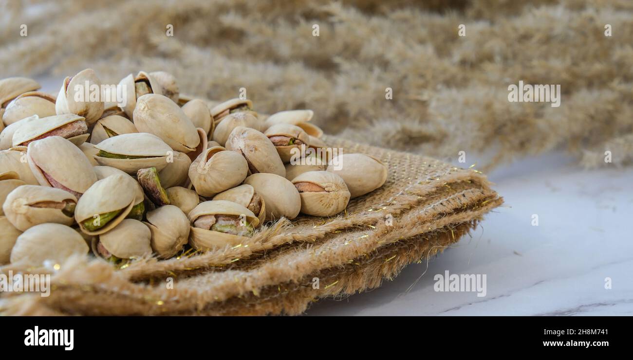 Pistachios in burlap sack on concrete table. Organic pistachios. Vegan