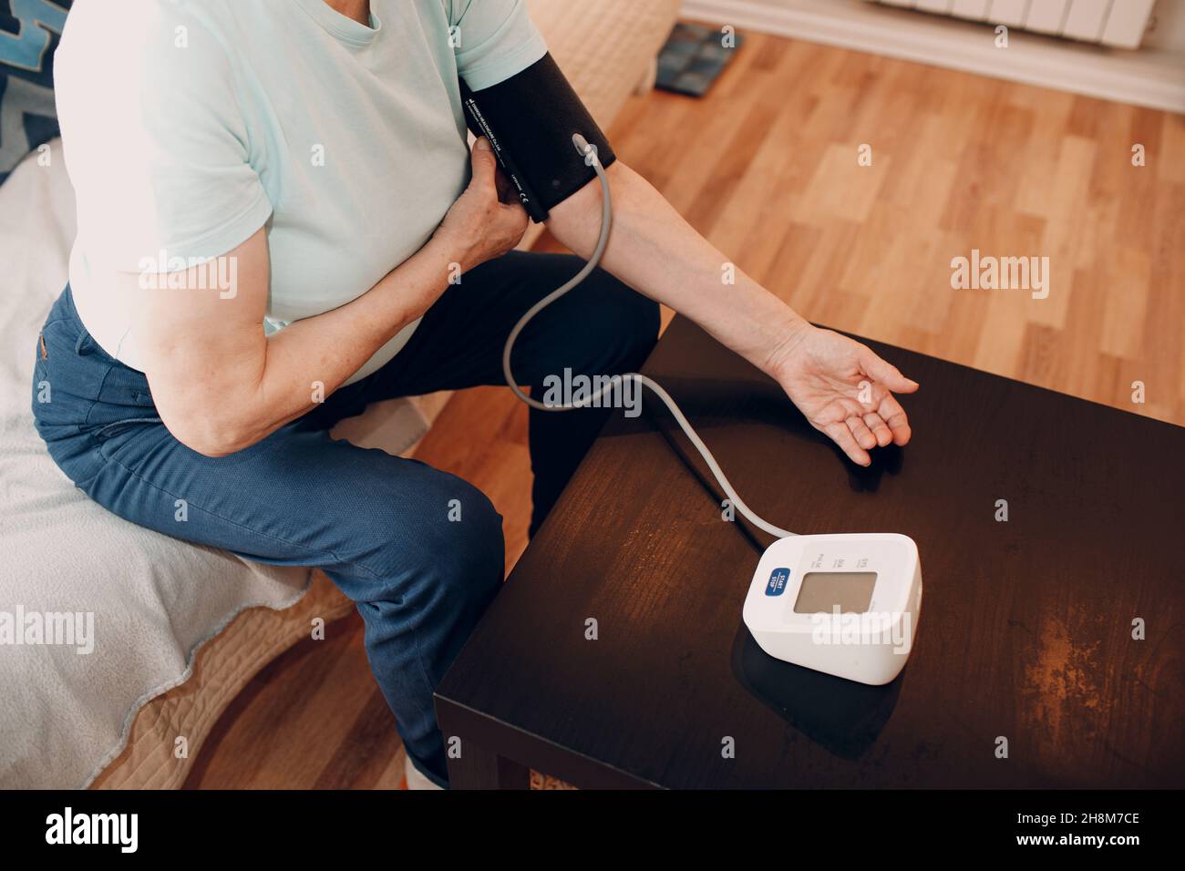 Senior woman taking measures blood pressure at home. Self care of