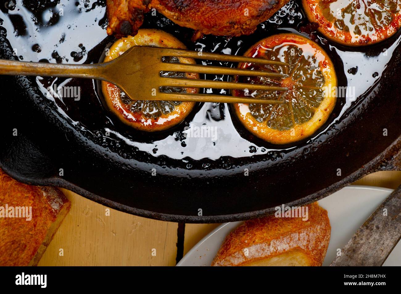 pork chop seared on iron skillet with lemon and spices seasoning Stock Photo