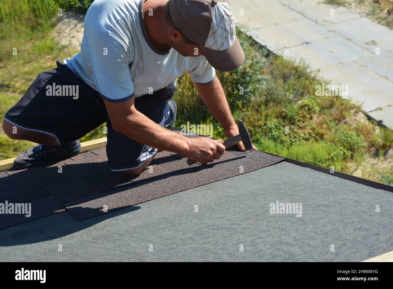 Asphalt shingles installation. A roofing contractor is installing