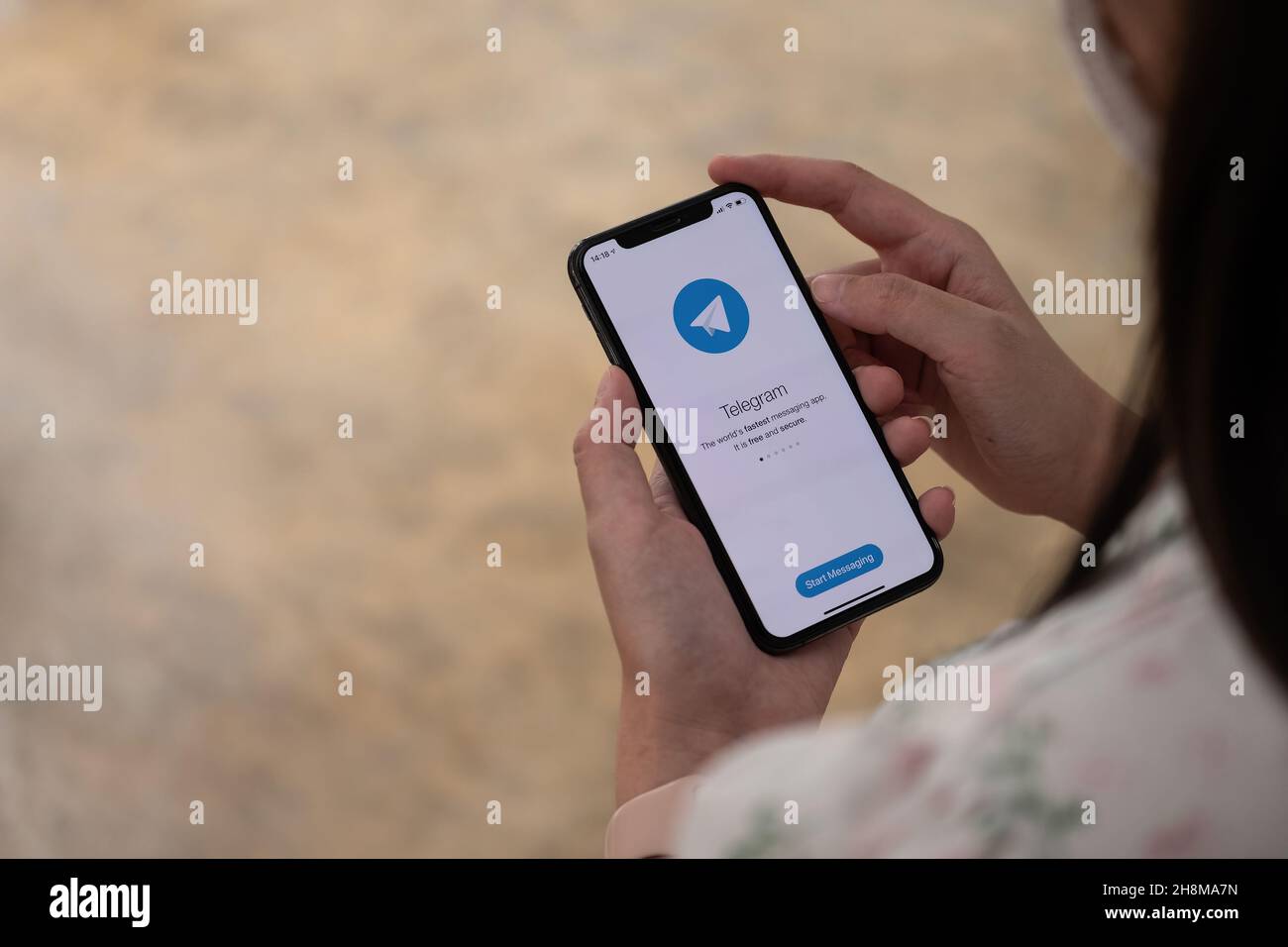 CHIANG MAI, THAILAND, NOV 14, 2021 : Woman hand holding iPhone X with social networking service Telegram on the screen. iPhone 10 was created and Stock Photo