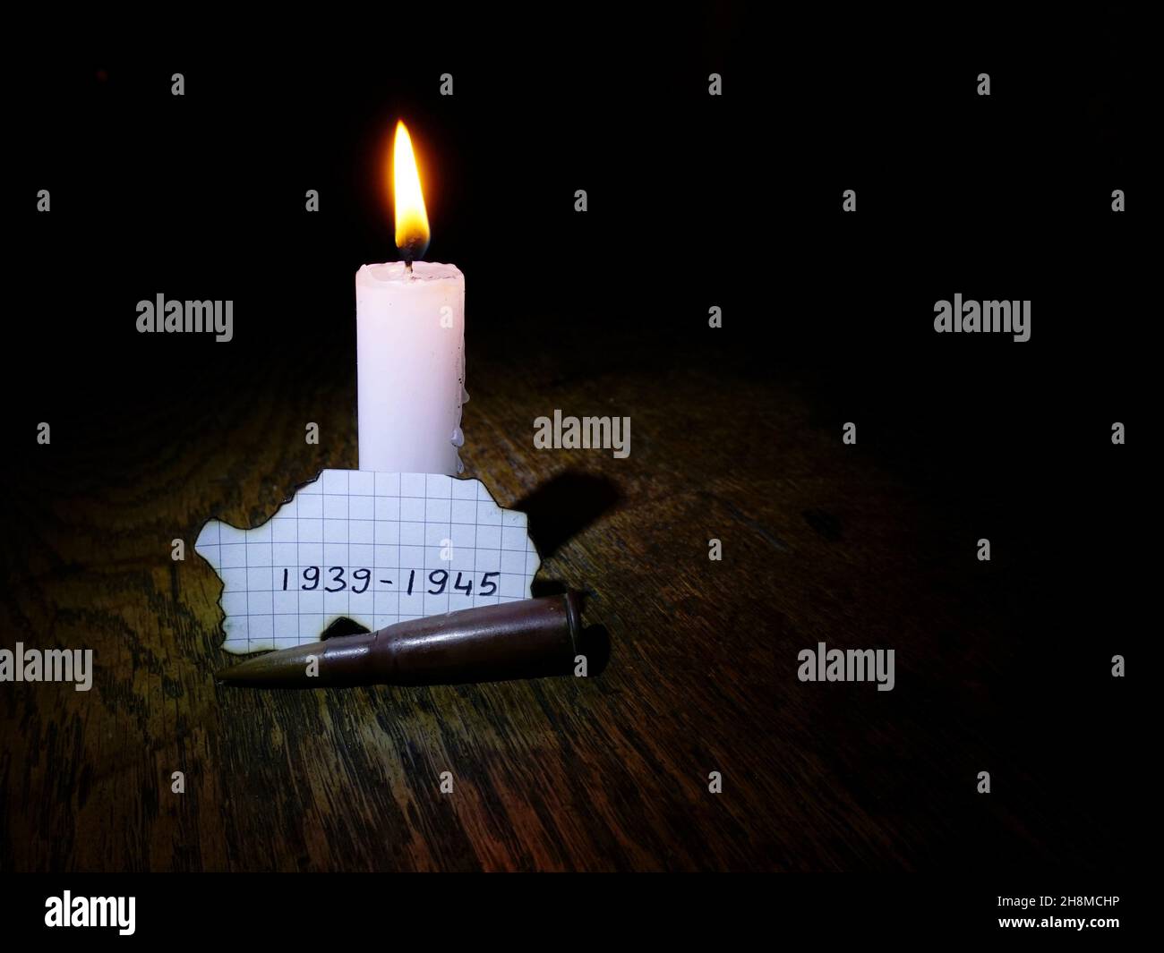 World War II anniversary dates, lit candle and a bullet Stock Photo