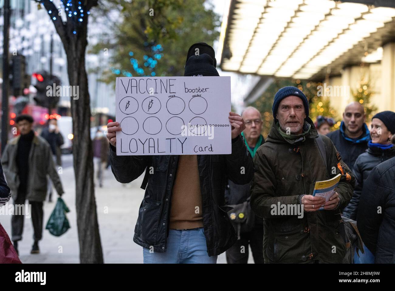 Coronavirus Vaccine campaigner holding a placard along Oxford Street during the build up to Christmas 2021 and the increasing COVID 19 cases in the UK. Stock Photo