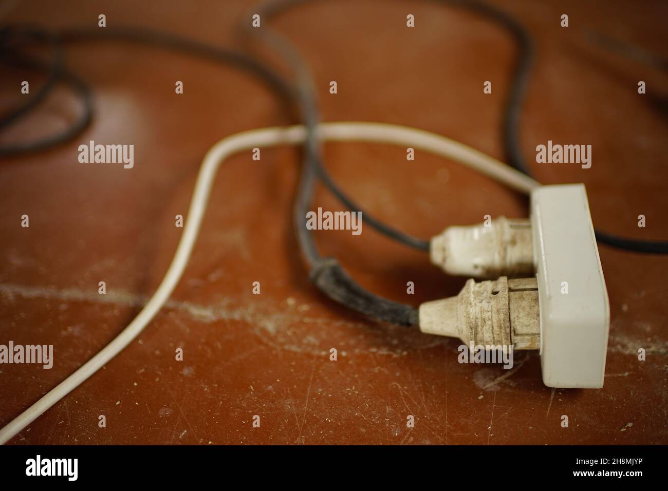 dirty extension cord with wires on the floor Stock Photo Alamy