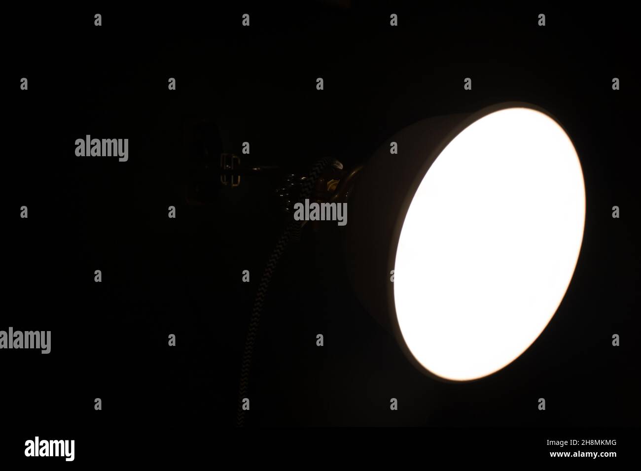 a lighted lamp in a room without light. black background with a lamp