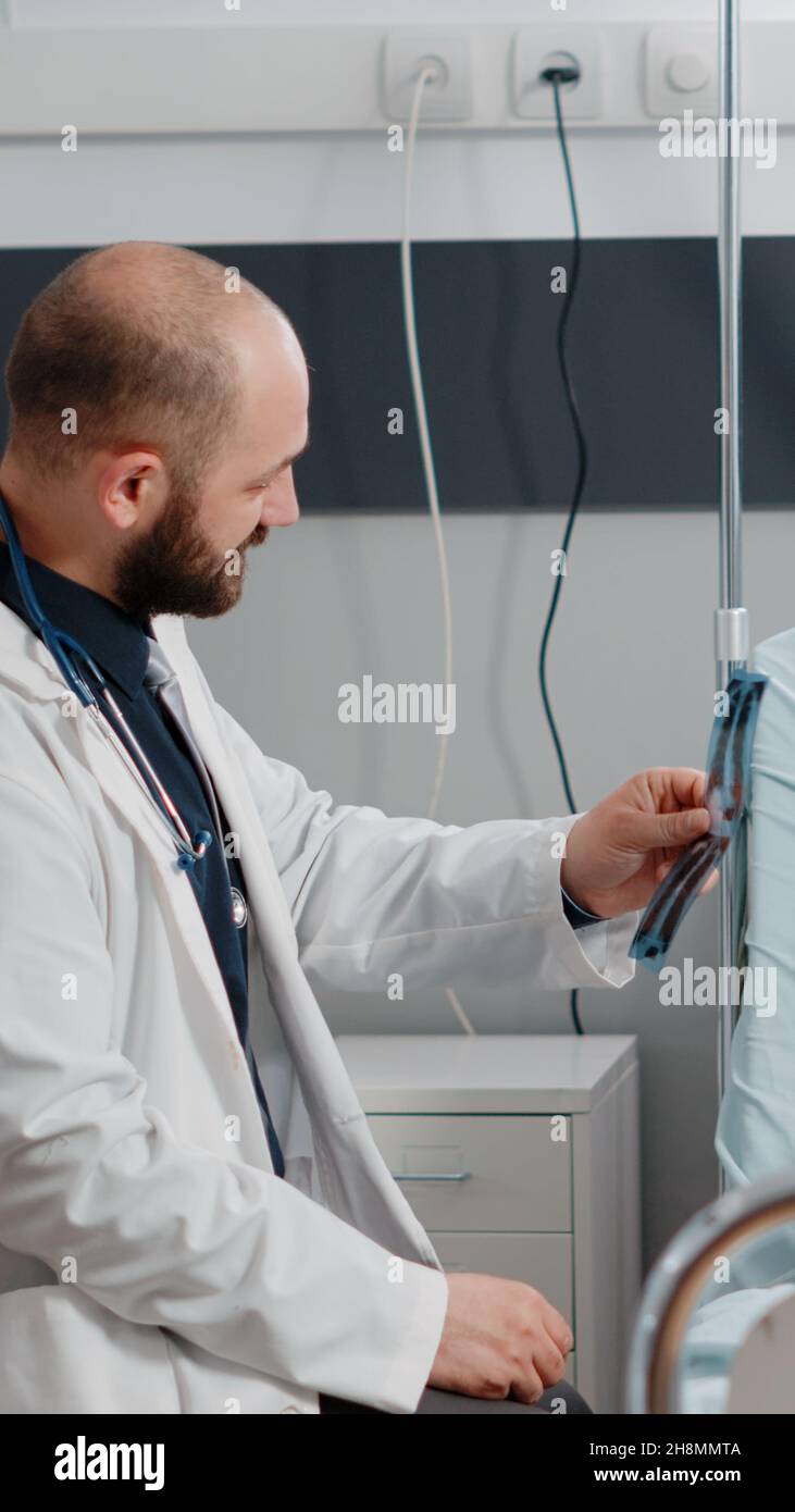 Doctor and old patient analyzing radiography for healthcare at clinic ...