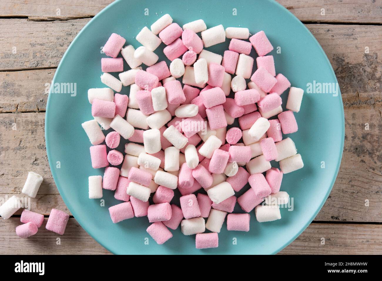 Sweet marshmallows topping in a blue plate on wooden table Stock Photo