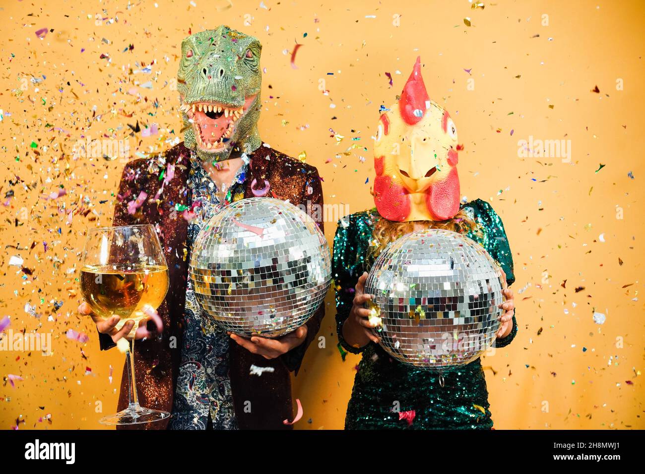 Crazy couple having fun holding disco balls and champagne glass at