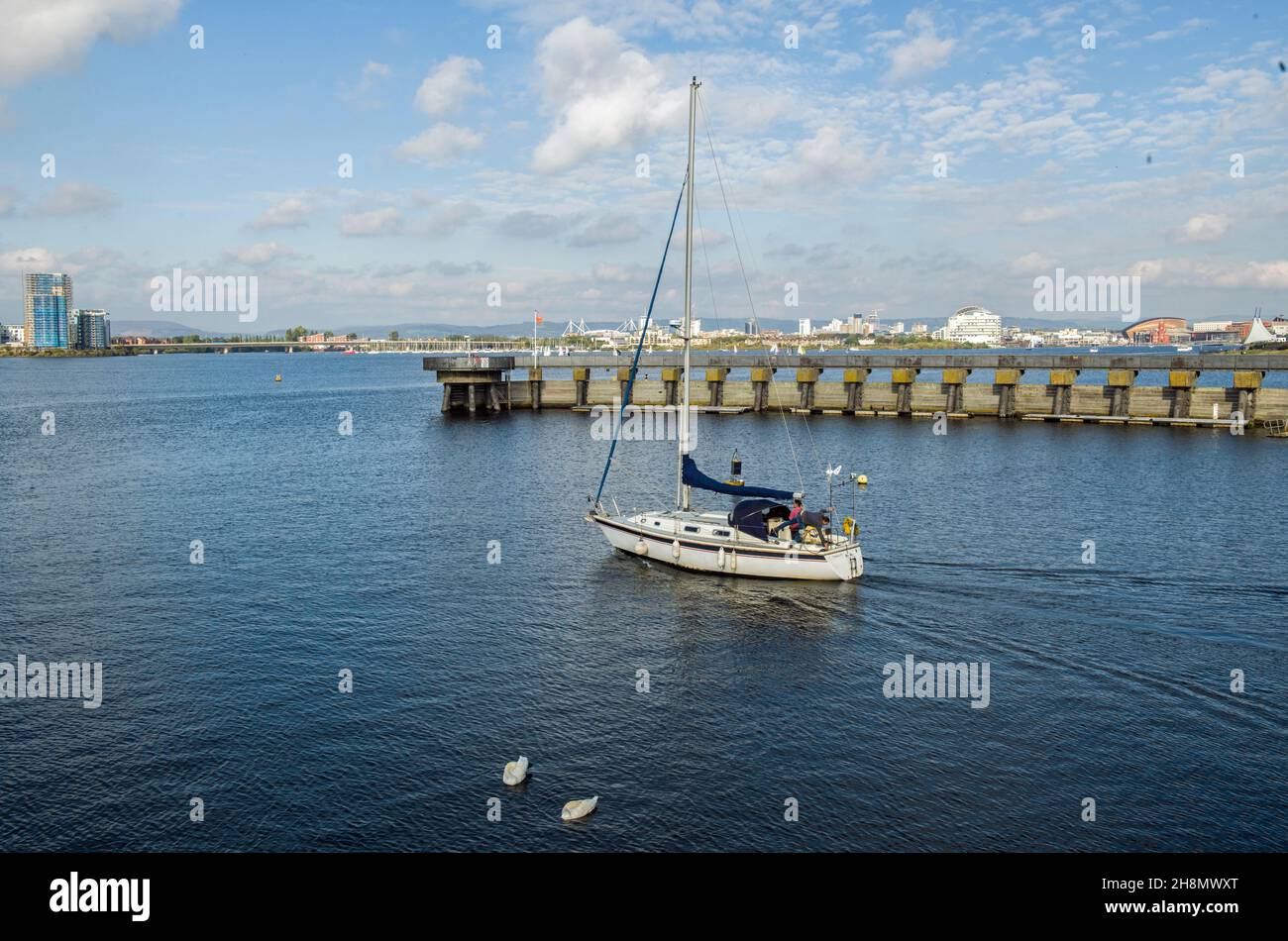 Yacht Boat heading into Cardiff Bay Lake from the Bay Barrage South Wales Stock Photo