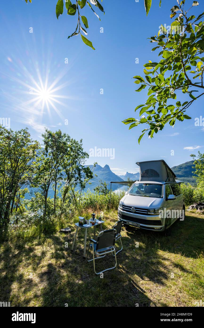 Camper standing by fjord with view of mountains, VW California, Lyngenfjord, Troms og Finnmark, Norway Stock Photo