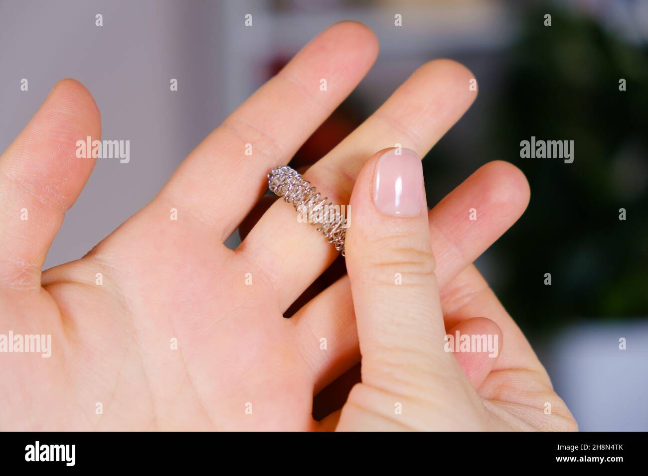 Massage ring for fingers in female hands close-up. Su Jok therapy, diagnosis and treatment of diseases, acupuncture and acupressure. Stock Photo