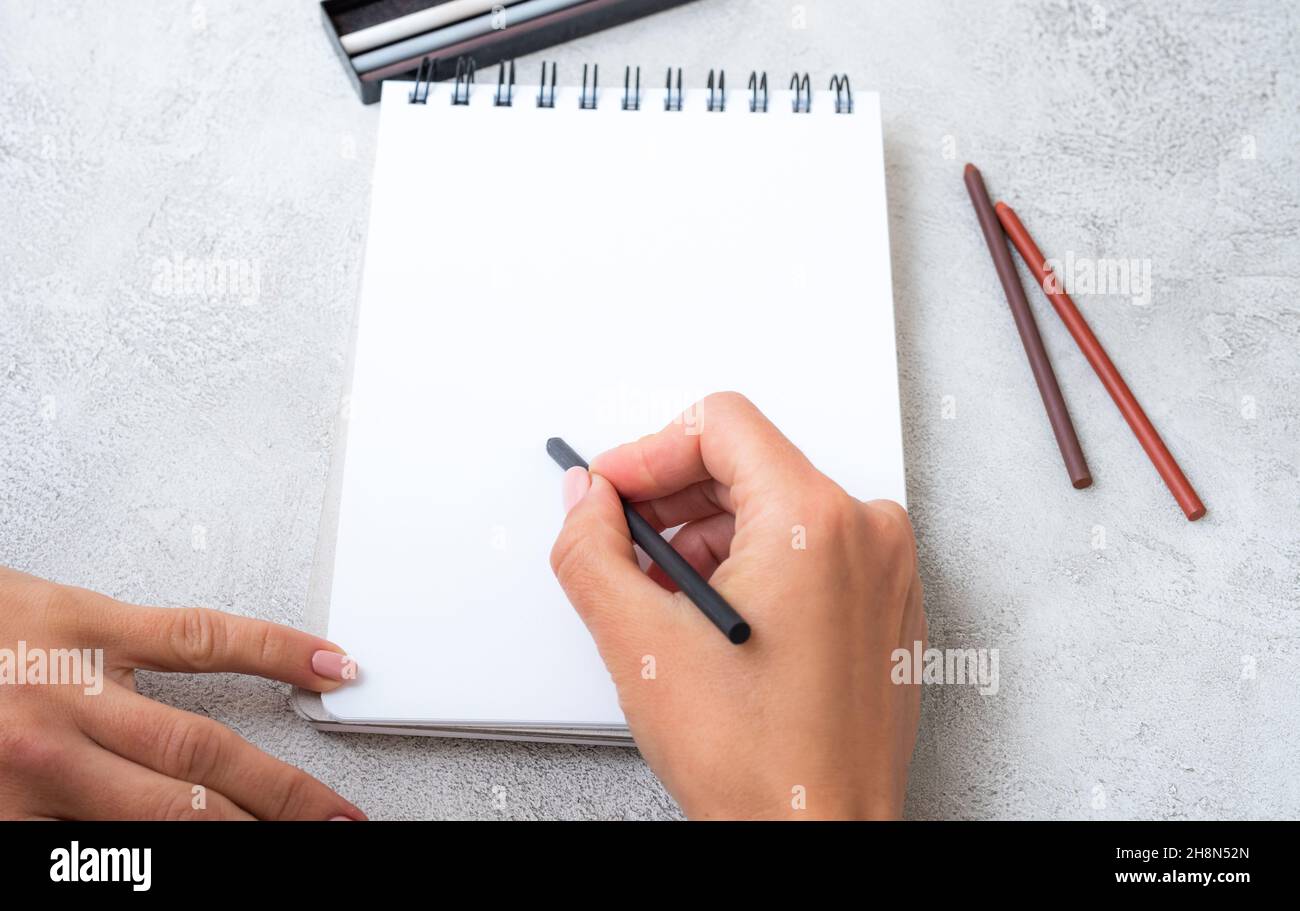 Girl's hands drawing in notebook Stock Photo