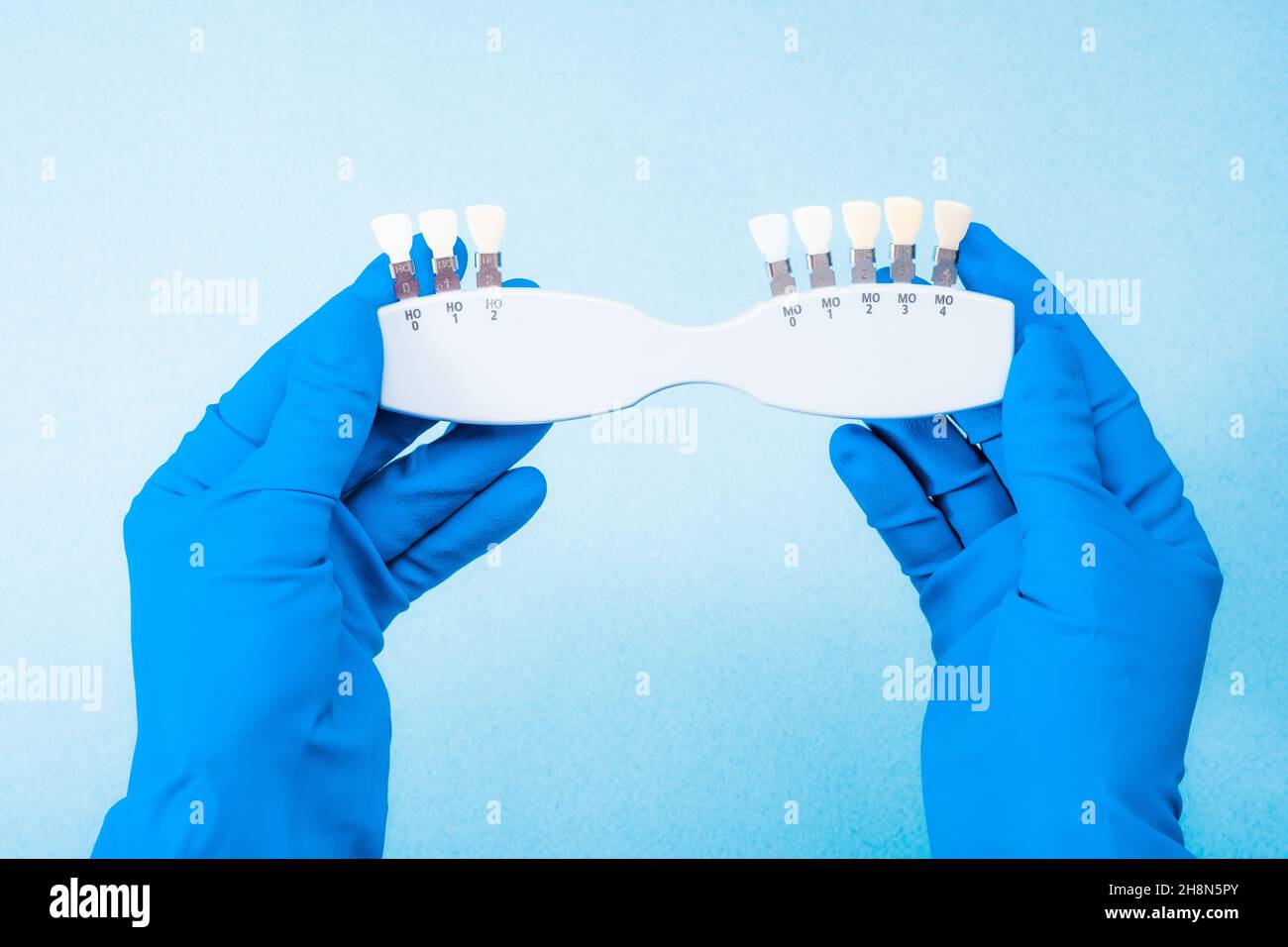 Hand in blue glove holding dental color palette Stock Photo