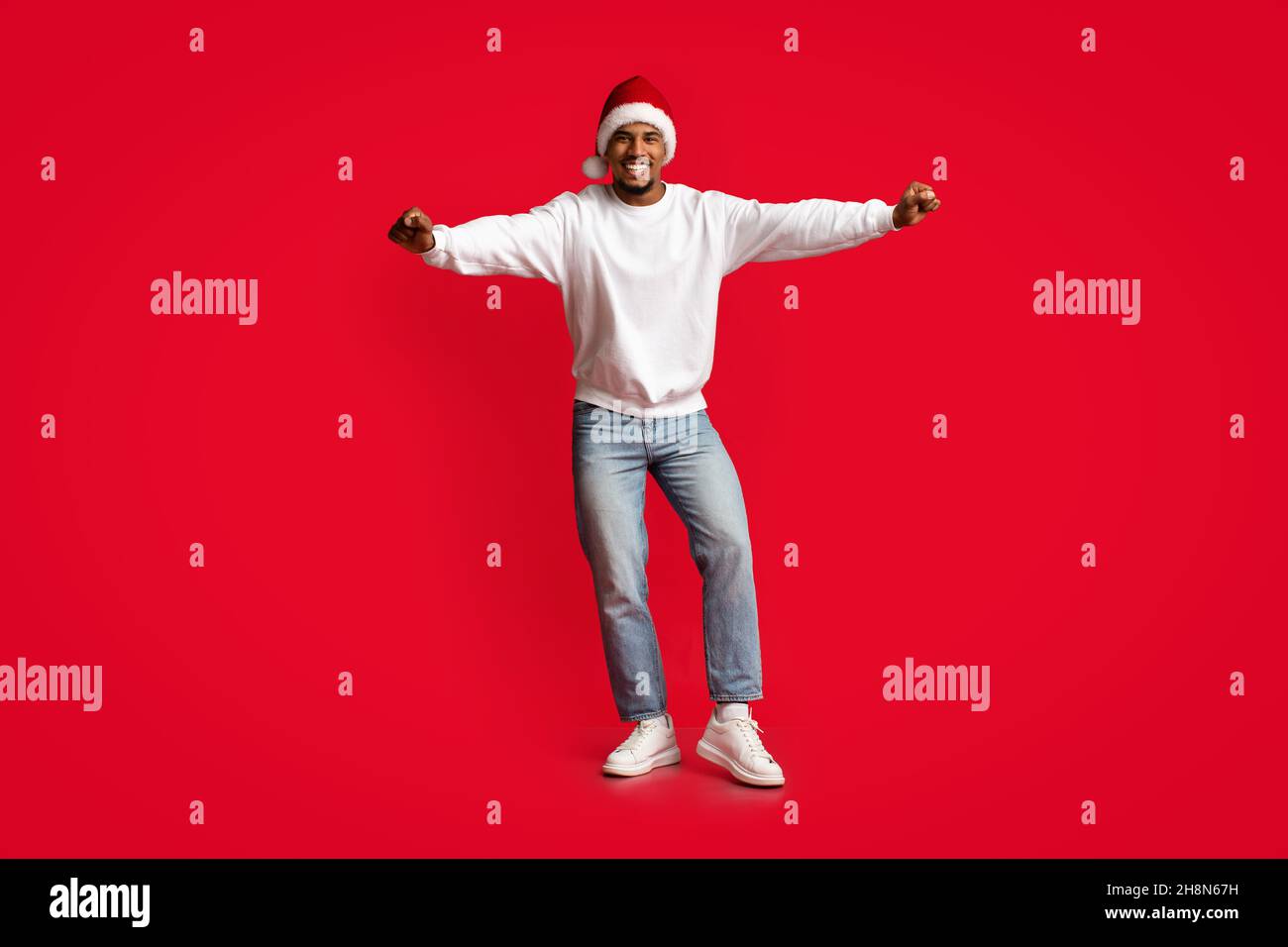 Joyful african american guy in Santa hat having fun Stock Photo