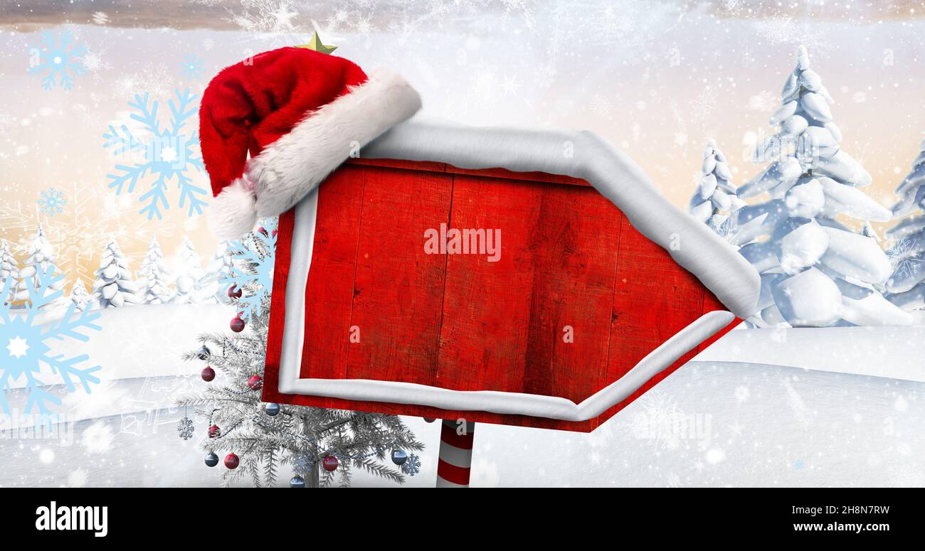 Composite image of santa hat on blank red directional sign board with copy space during winter Stock Photo