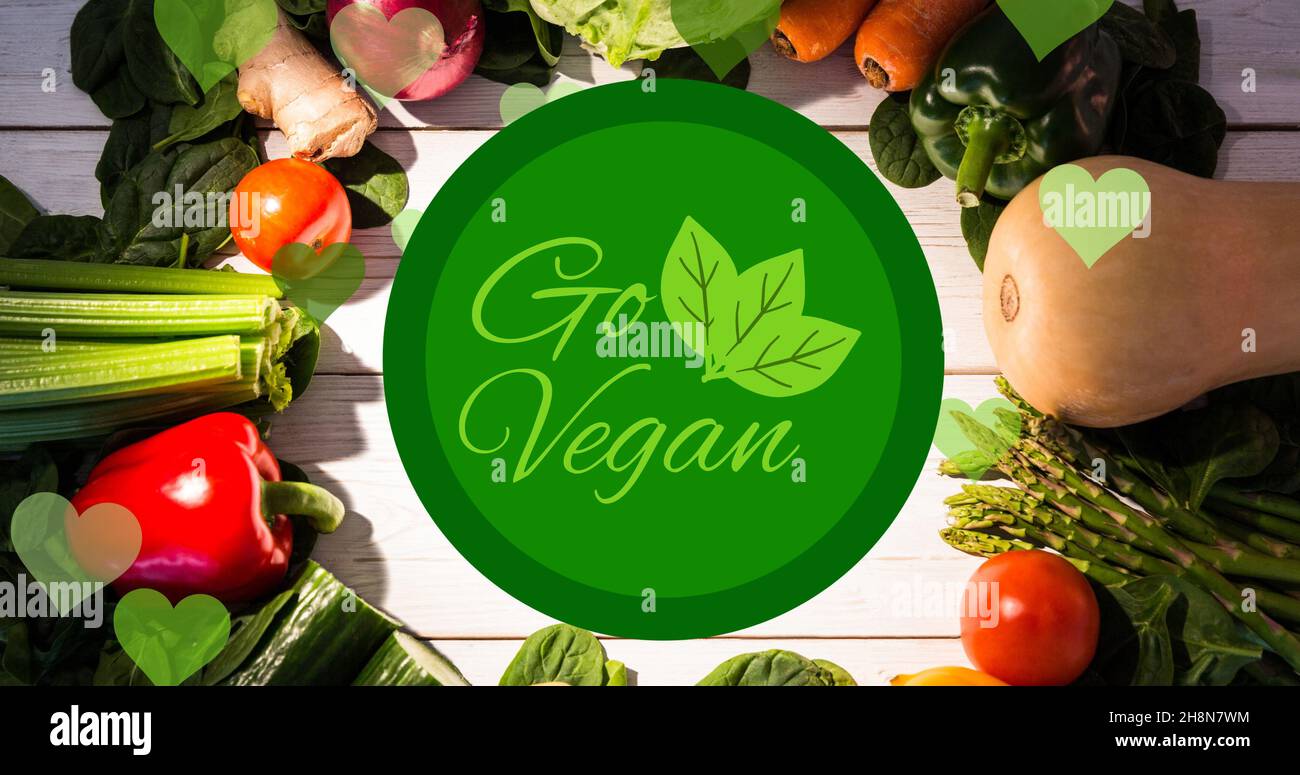 Directly above view of go vegan symbol text over fresh vegetables arranged on table Stock Photo