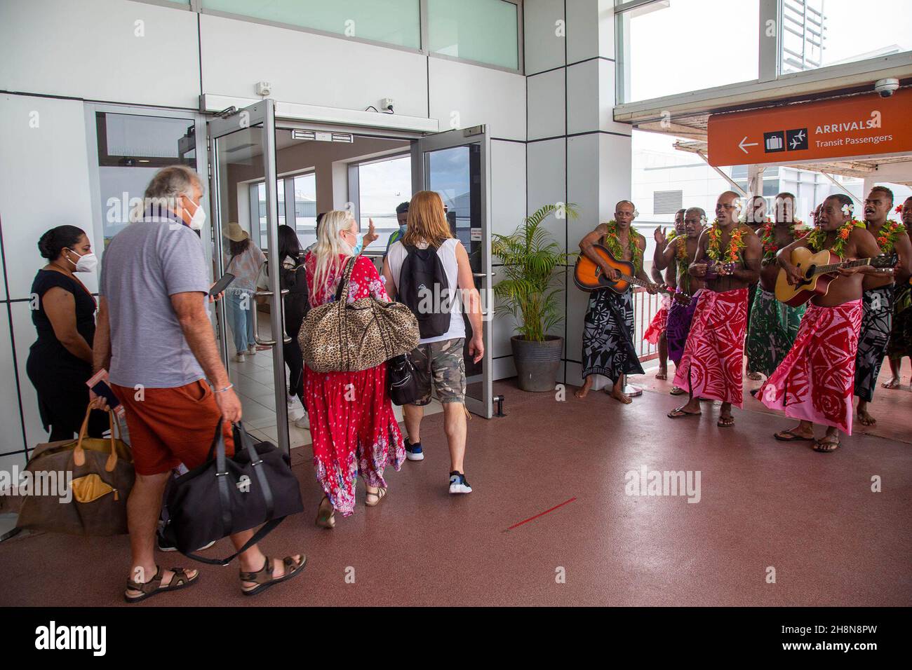 (211201) -- SUVA, Dec. 1, 2021 (Xinhua) -- Passengers are welcomed at the Nadi International Airport in Fiji's third largest city on the western side of Viti Levu, Dec. 1, 2021. Hundreds of tourists arrived in Fiji on Wednesday with the reopening of the country's international borders after a 20-month hiatus due to the COVID-19 pandemic. (FIJI SUN/Handout via Xinhua) Stock Photo