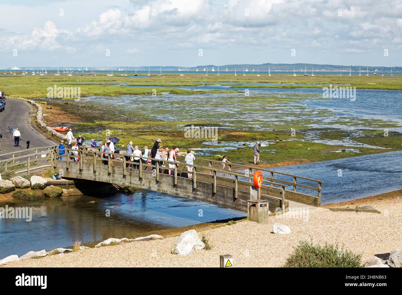 People crab fishing on a bridge near Milford on sea looking across Hurst point. Stock Photo