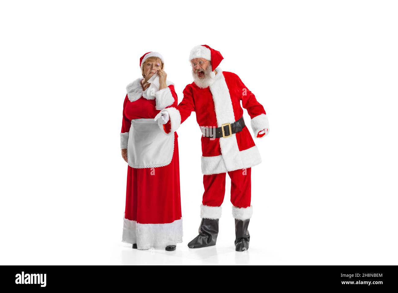 Portrait of two people, man in Santa Claus costume and crying woman, missis Claus isolated on white background. Stock Photo