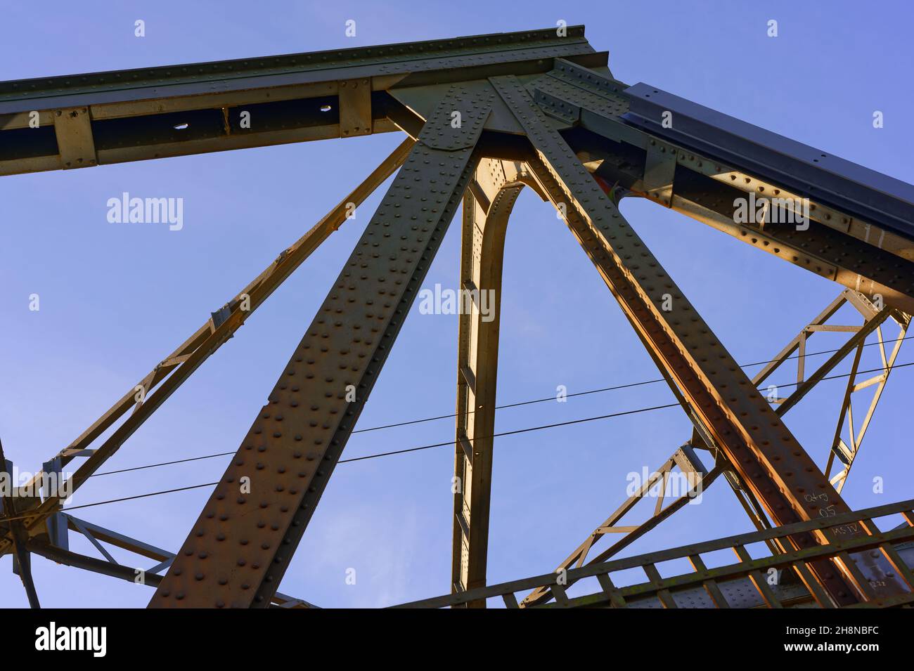 Eisenbahnbrücke vor blauem Himmel, Konstruktionsdetails mit Nieten, wenig Wolken Stock Photo