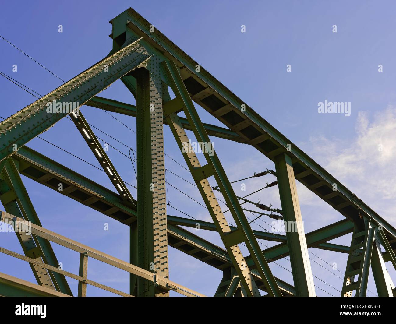 Eisenbahnbrücke vor blauem Himmel, Konstruktionsdetails mit Nieten, wenig Wolken Stock Photo