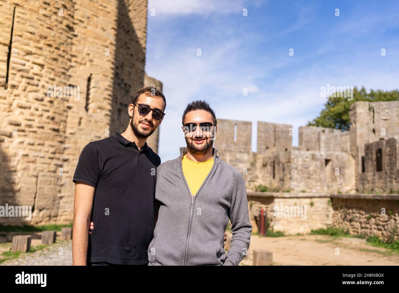 Gay couple embracing next to the walls of a medieval castle. France Stock Photo