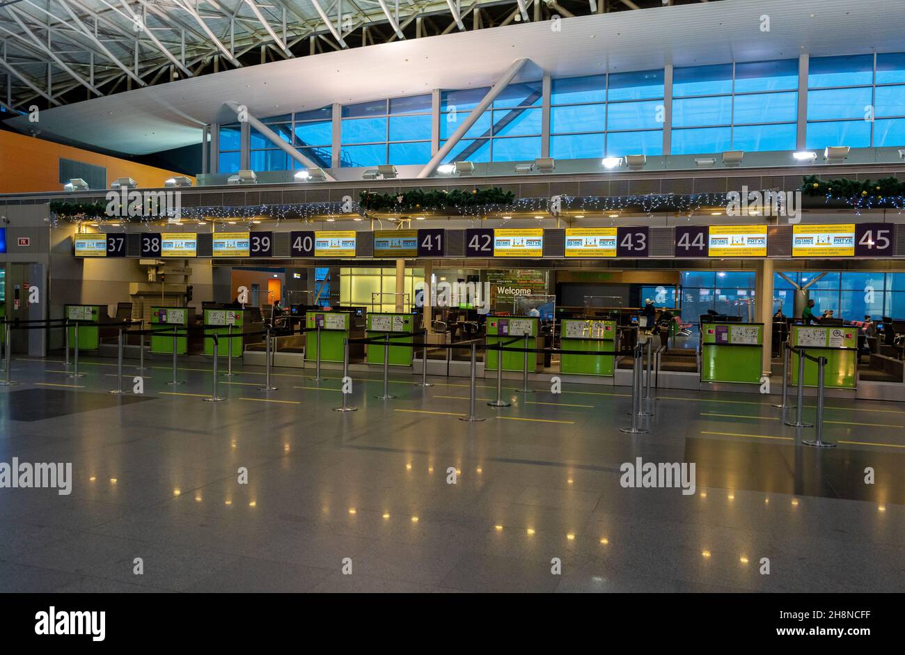 Ukraine, Kyiv - December 29, 2020: Empty check-in counter for a flight to the airport. Christmas. New Year decorations at the Boryspil airport. Garlands and lights, winter on vacation. Stock Photo