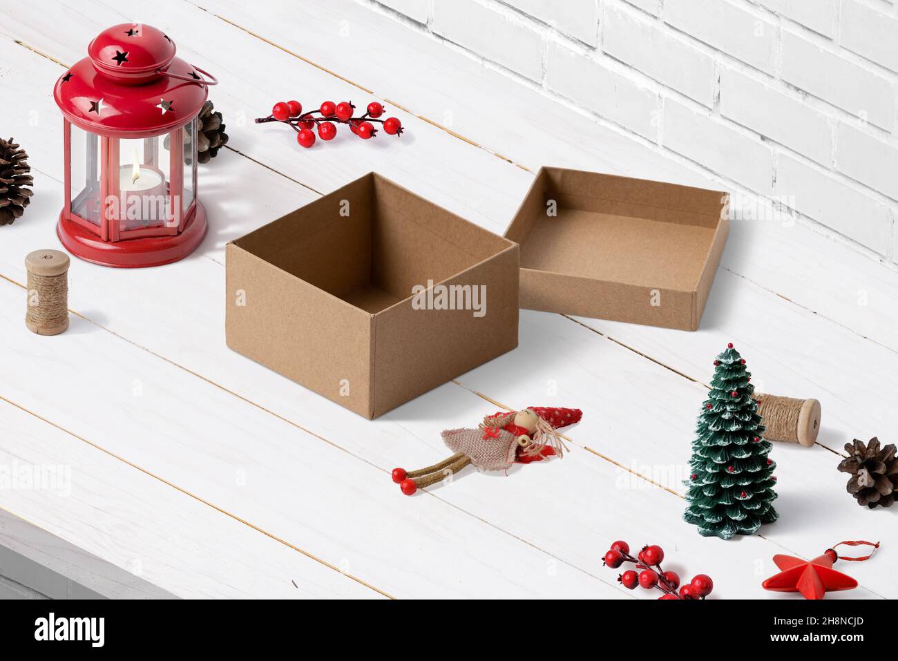 Unpacking a Christmas present. Box, a doll and Christmas decorations with a lantern on desk. Isometric composition Stock Photo