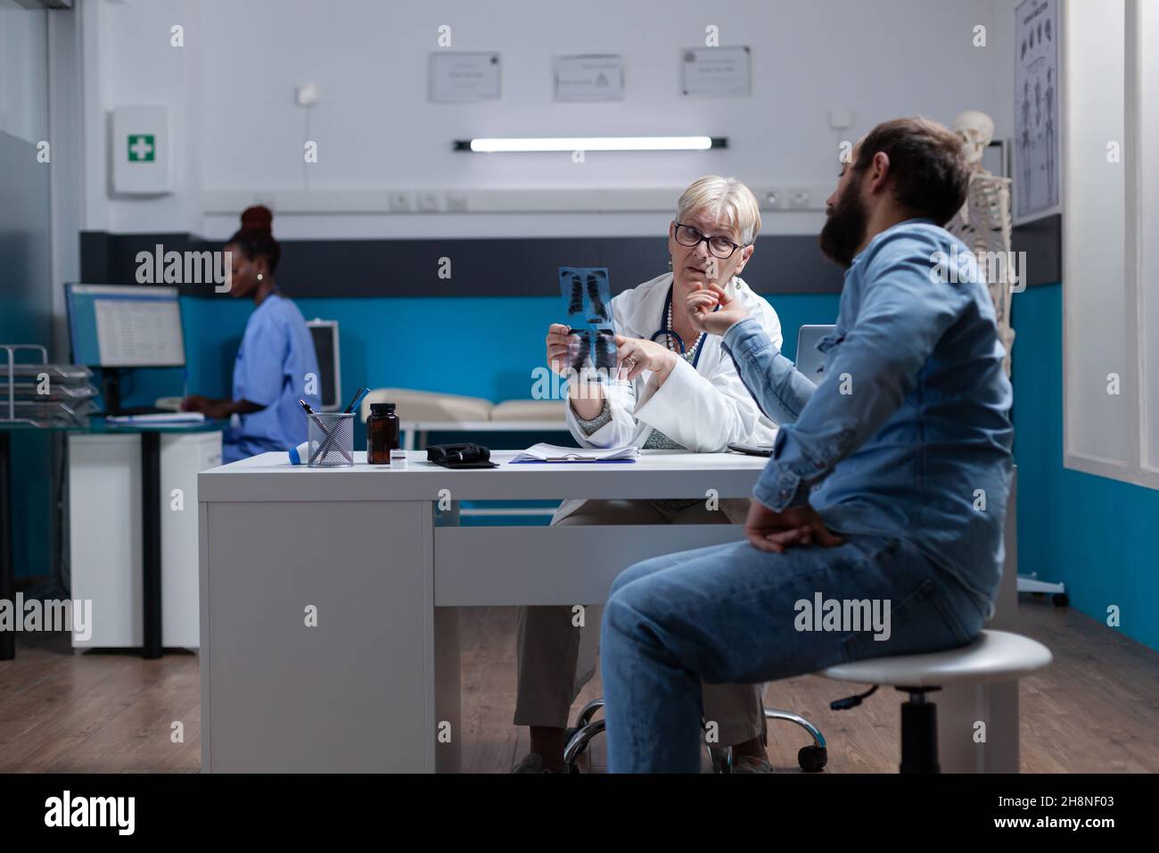 Physician showing x ray scan results to patient at checkup visit ...