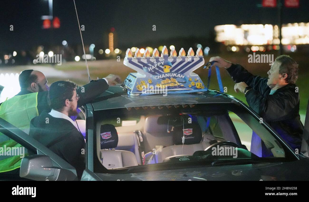 Chesterfield, United States. 30th Nov, 2021. Participants in the annual Chanukah car menorah parade place a giant menorah on top of their car before the start in Chesterfield, Missouri on Tuesday, November 30, 2021. Cars travel for several miles in the parade with a lighted menorah attached to their cars, listening to Chanukah music. Photo by Bill Greenblatt/UPI Credit: UPI/Alamy Live News Stock Photo