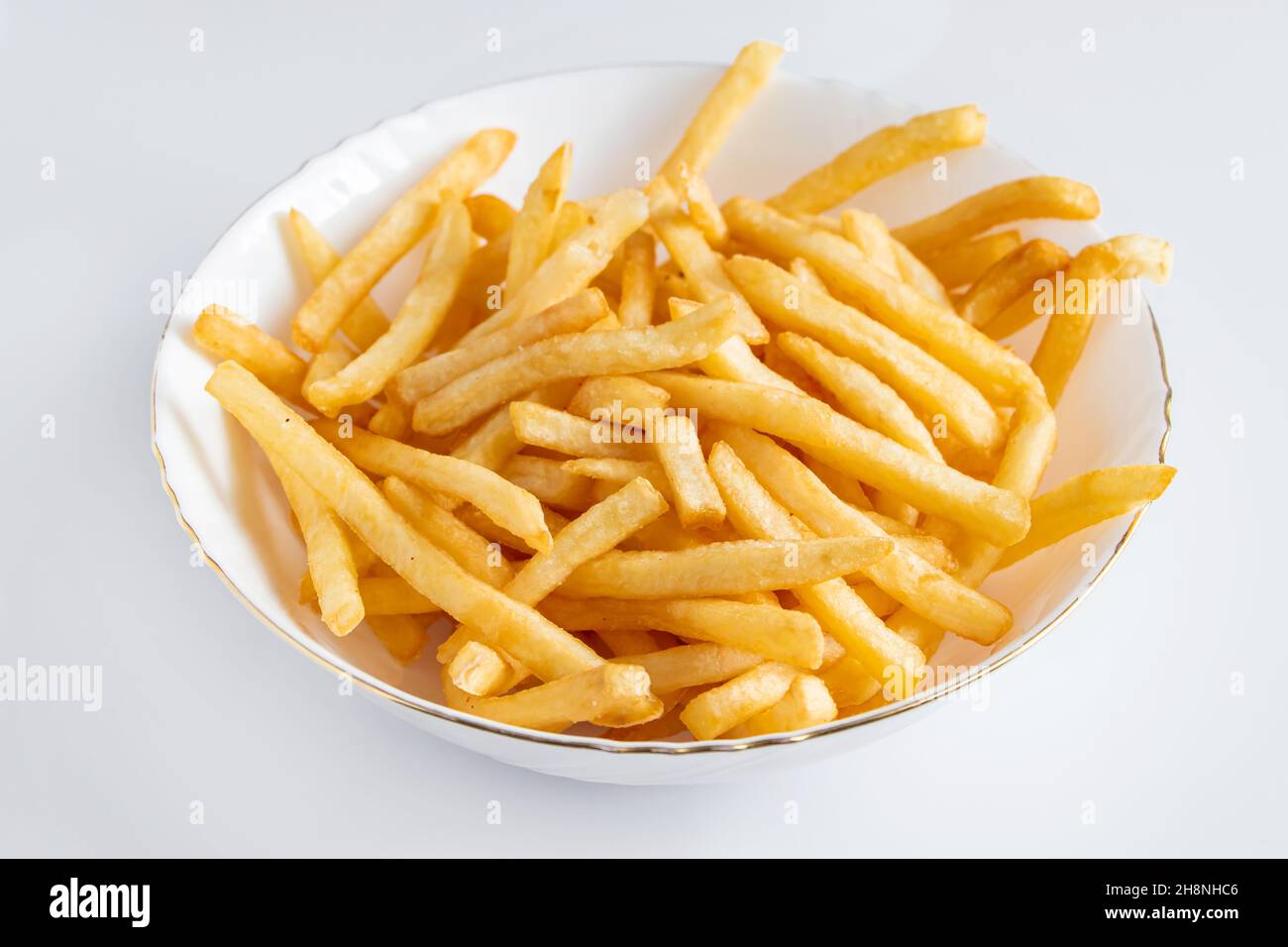 Crispy fries in a plate on a white background. Hot american fast food. Stock Photo