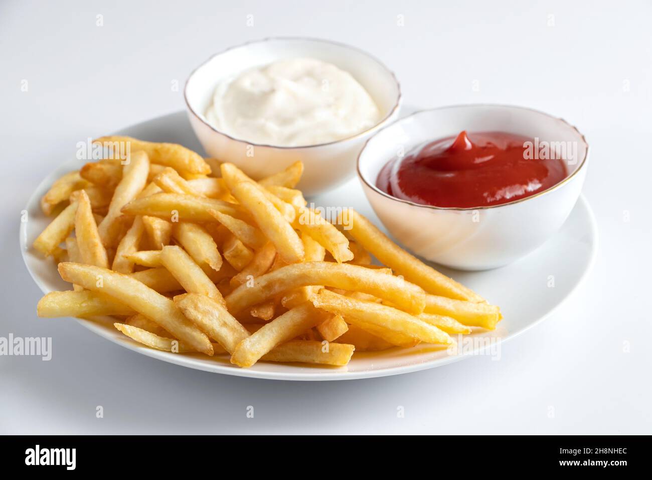 Crispy fries in a plate on a white background. Hot american fast food. Stock Photo