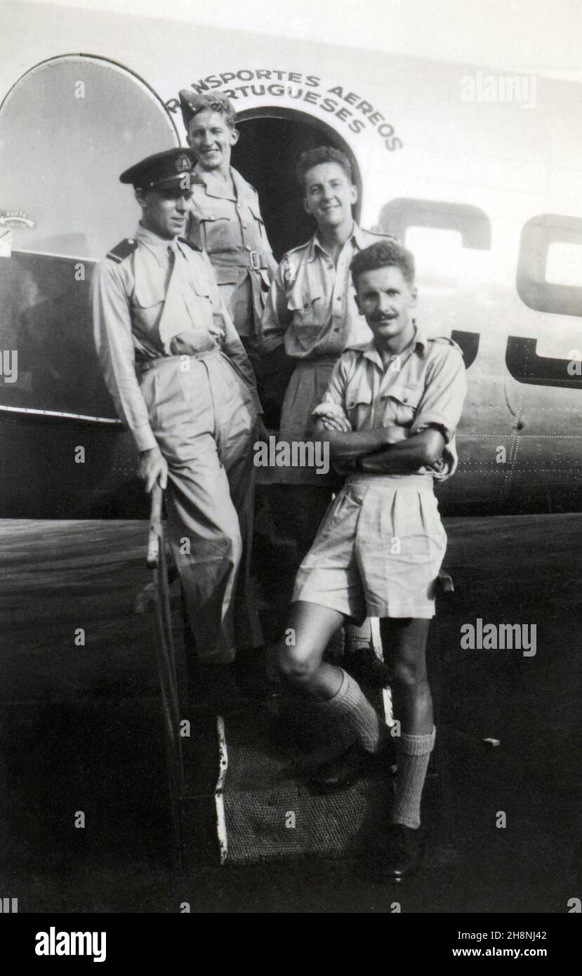 Accra Airport, Ghana, February 1946. Three RAF personnel and a Portuguese pilot in front of a TAP – Transportes Aéreos Portugueses, DC-3 Dakota. Founded in March 1945, TAP only began commercial flights in September 1946. The flight was probably a test-run for the Linha Aérea Imperial, a twelve-stop colonial service to Angola and Mozambique, which began in December 1946. Stock Photo