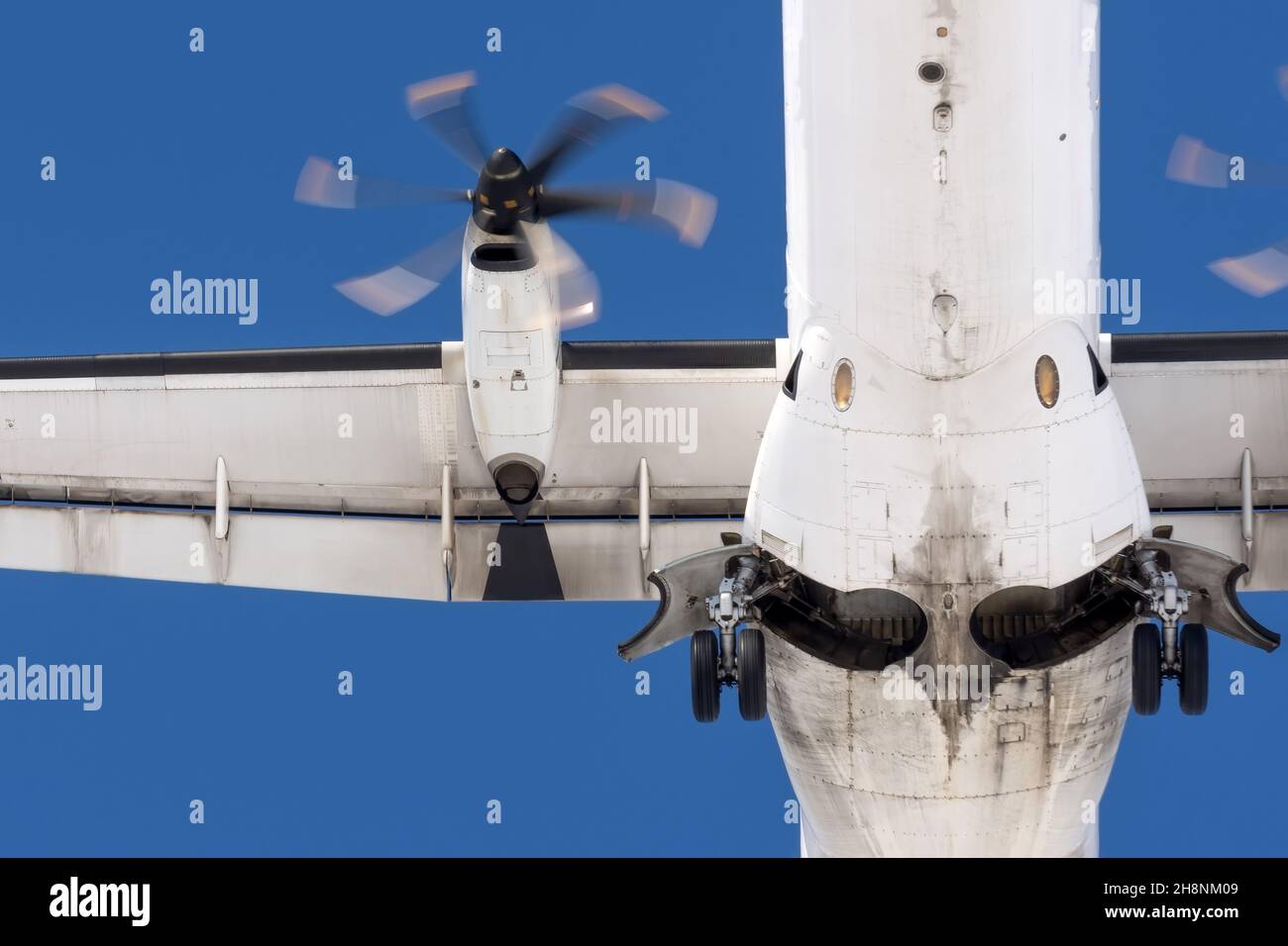 Turboprop aircraft flies overhead, view of the landing gear, wing and engine Stock Photo