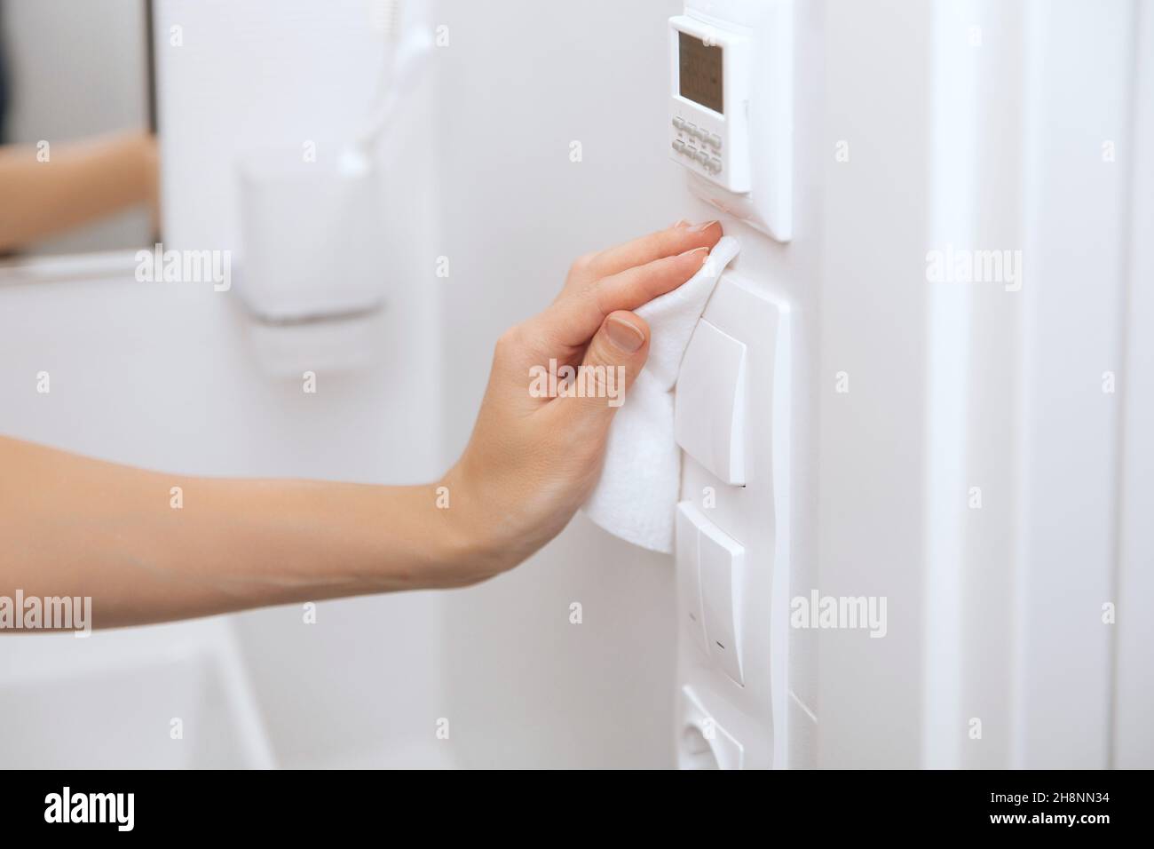 Cleaning switches and sockets with a microfiber cloth. Woman hand using