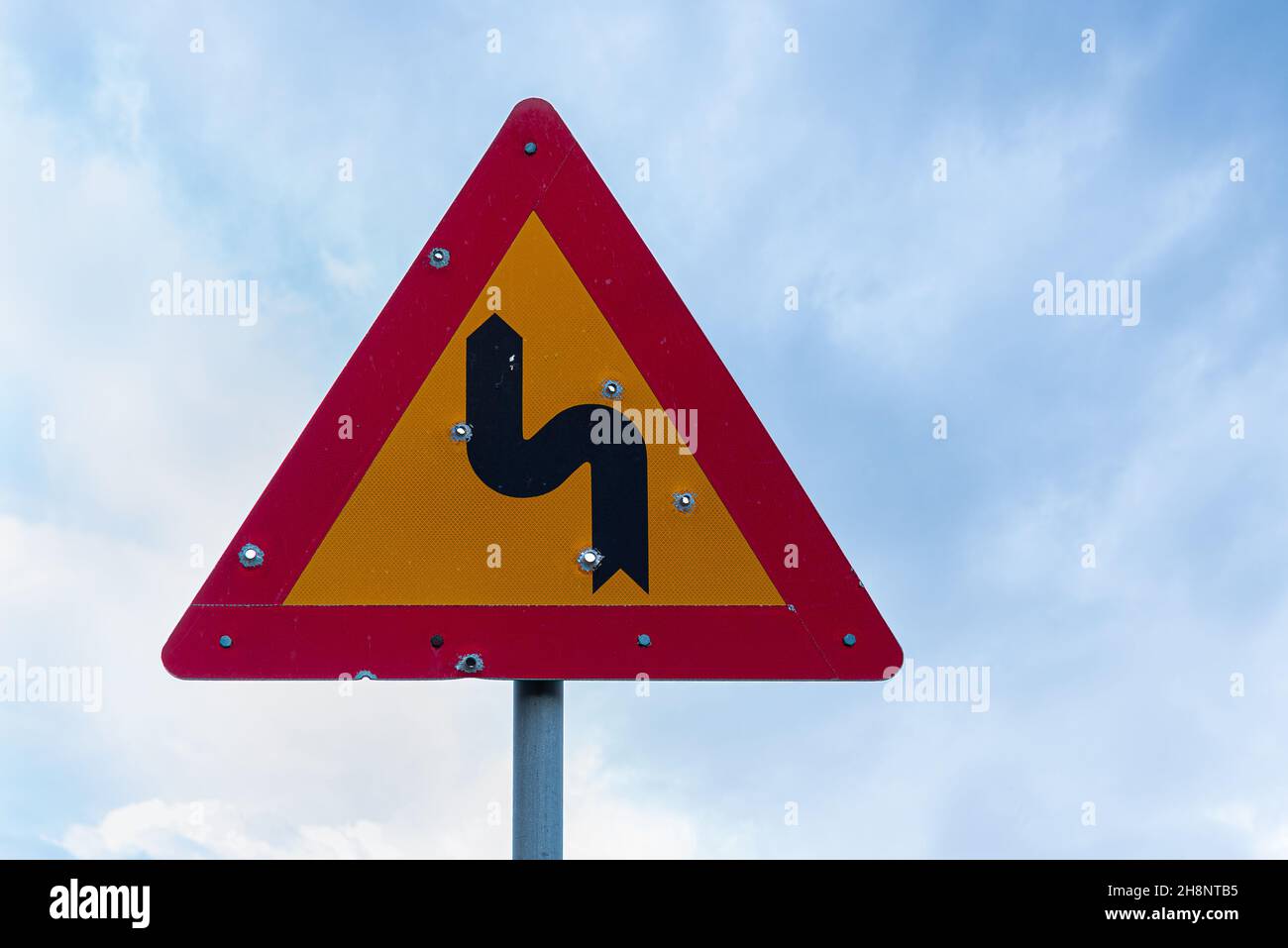 bullet holes in a road sign aginst the blue sky, Crete, Oktober 14, 2021 Stock Photo
