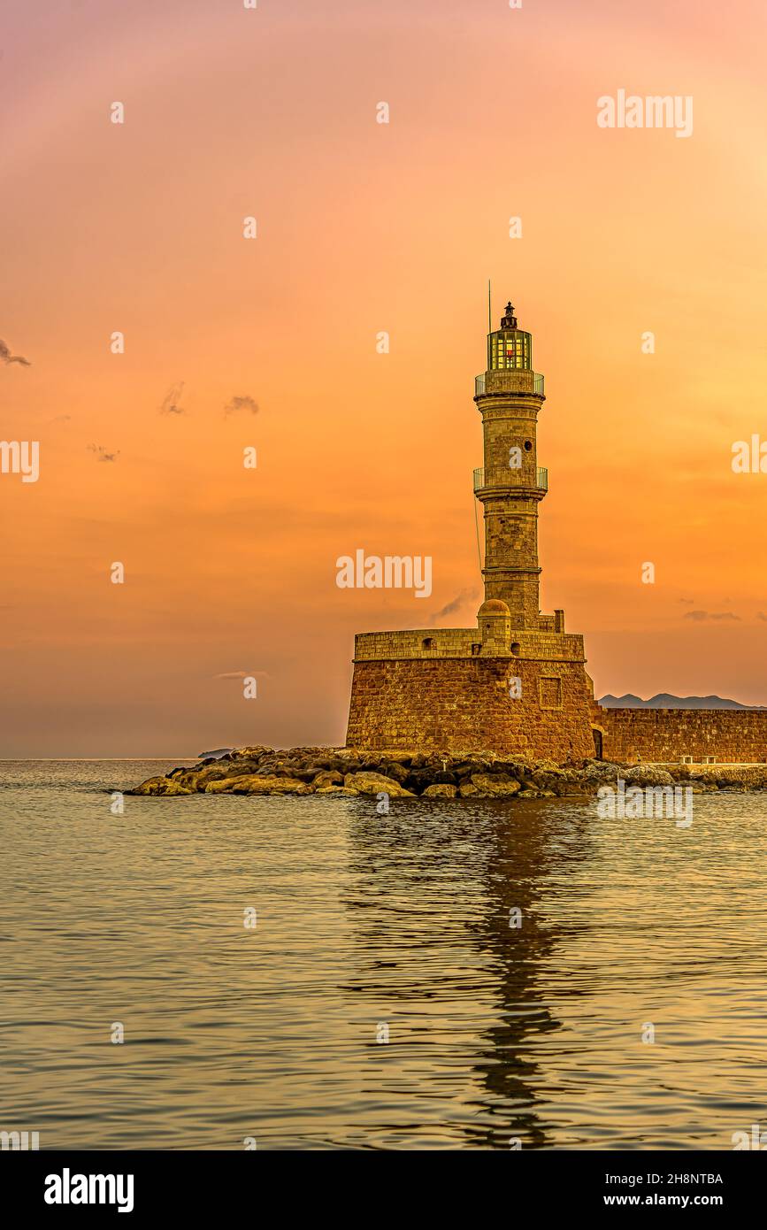 the lighthouse in the harbour of Chania glowing in the sunrise, Chania, Crete, Greece, October 15, 2021 Stock Photo