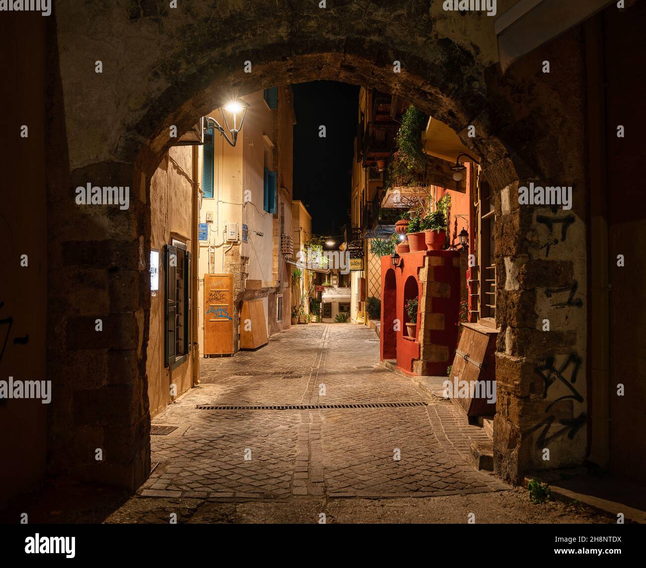 medieval stone arch and a picturesque street at night in the old town of Chania, Crete, Greece, October 15, 2021 Stock Photo